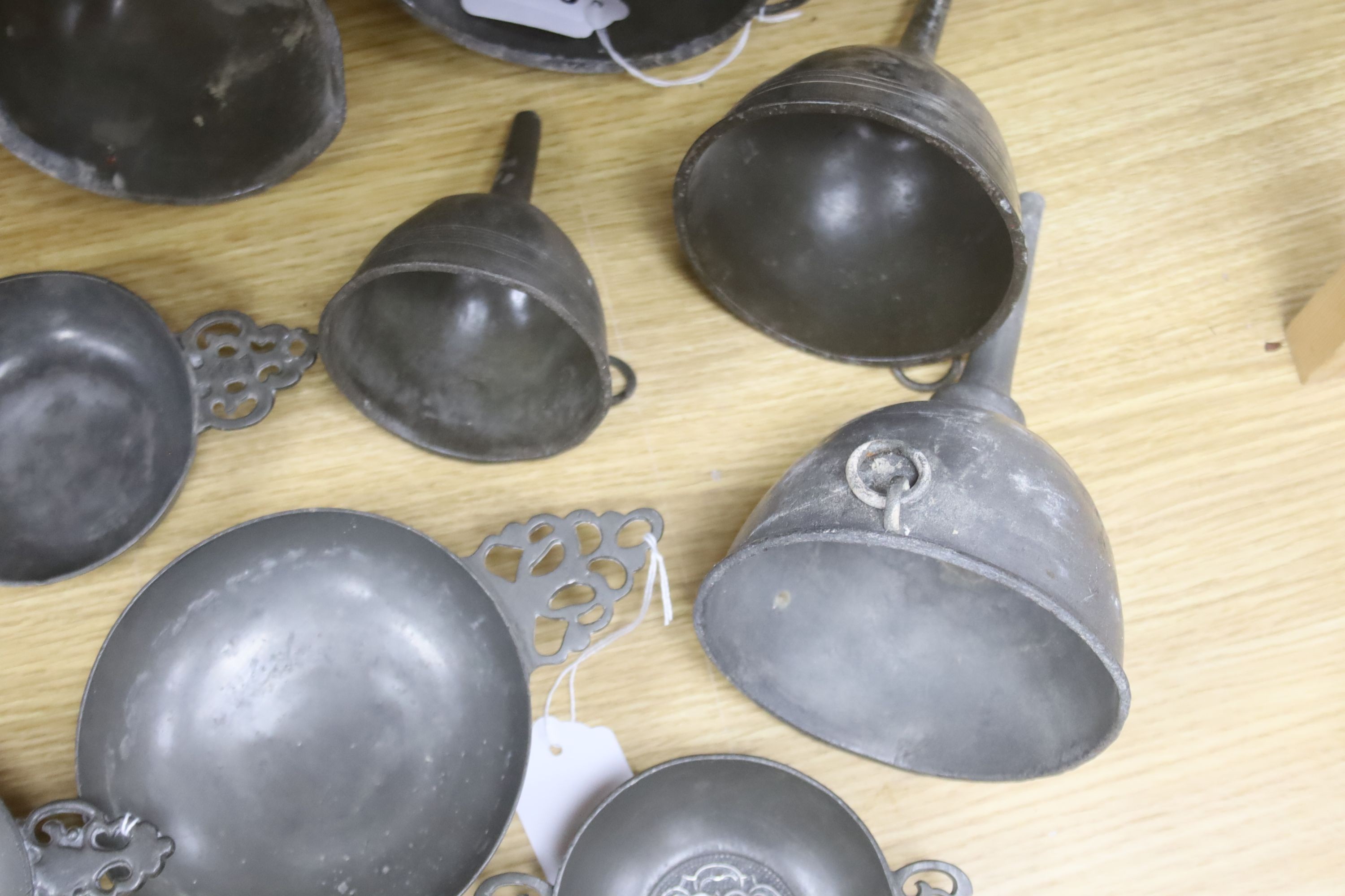 Nine items of 18th and 19th century pewter, including three quaich, a blood letting type bowl and five wine funnels, widest 15cm